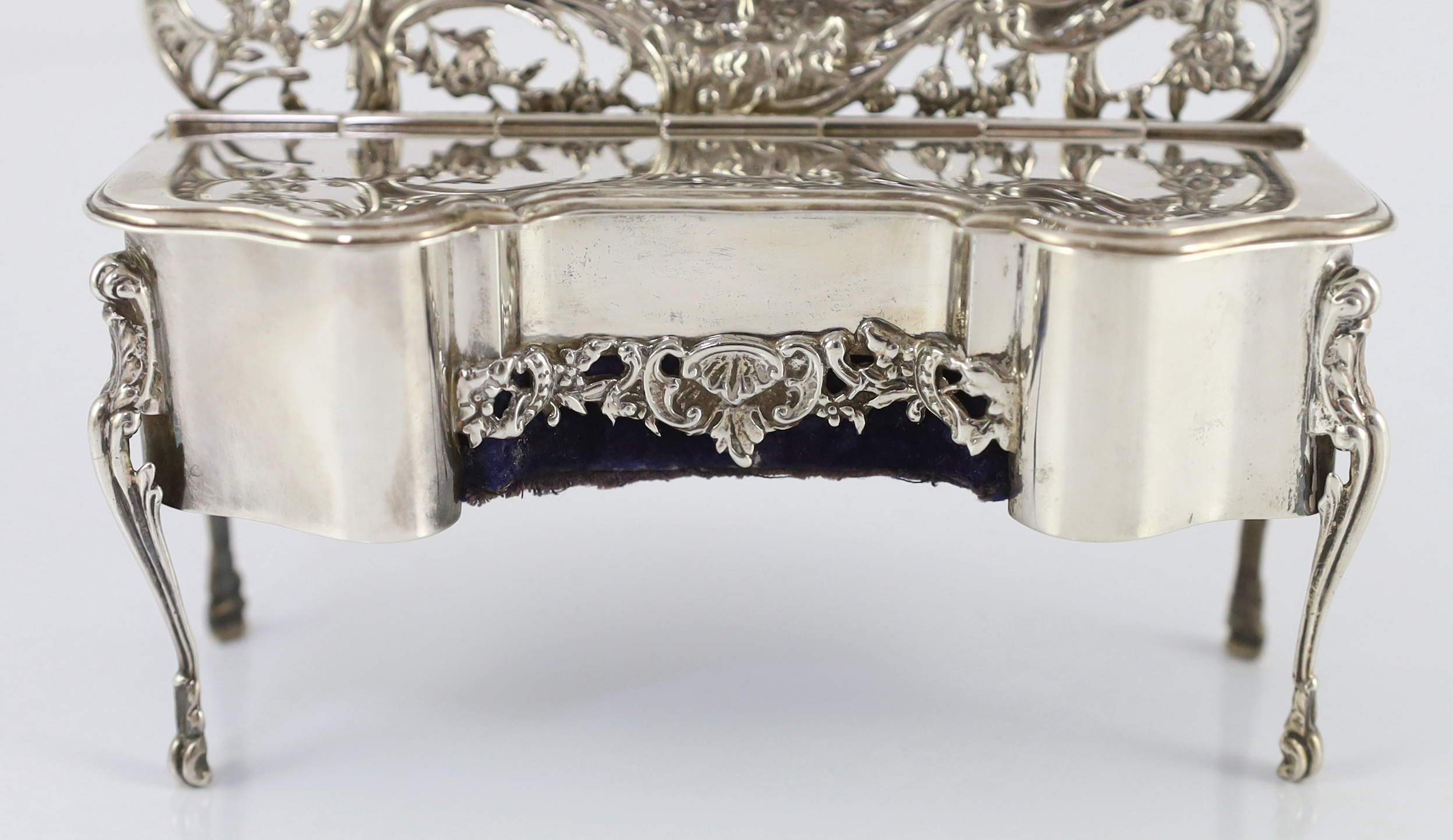 An Edwardian embossed silver novelty trinket box, modelled as a dressing table with raised back, on cabriole legs, by William Comyns